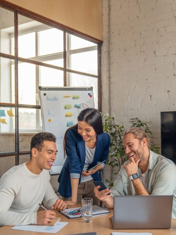 vertical-shot-of-multiracial-business-people-with-laptop-and-smartphone-having-meeting-in-office-.jpg